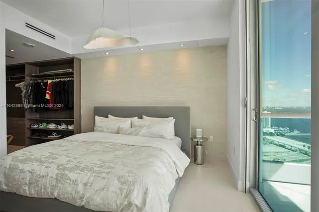 a large bed in a bedroom next to a window