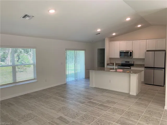 a kitchen with a refrigerator and a stove top oven