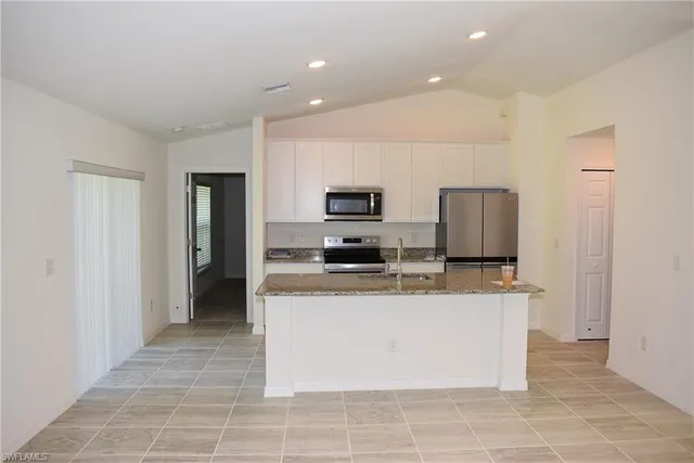 a kitchen with stainless steel appliances a refrigerator sink stove microwave and cabinets