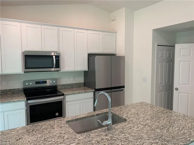 a kitchen with a sink stove and refrigerator