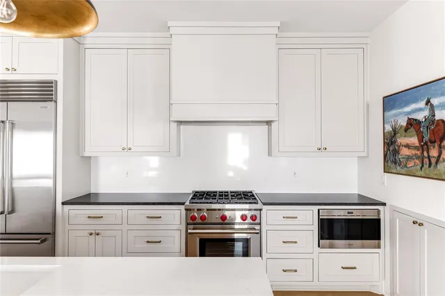 a kitchen with white cabinets and white appliances