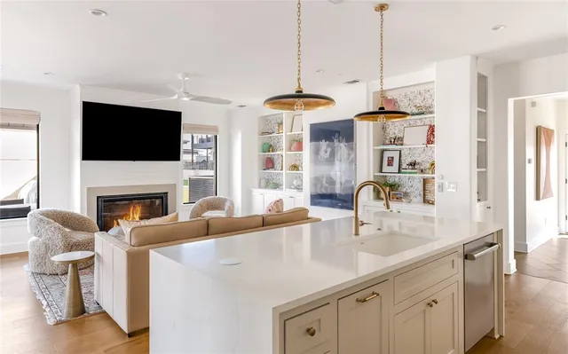 a kitchen with stainless steel appliances granite countertop a sink a stove and a flat screen tv