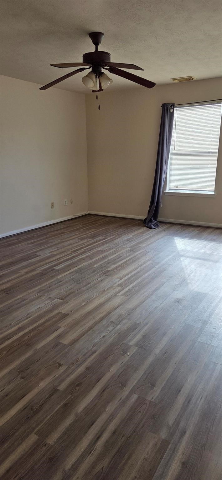 14127 Magnus Lane Houston, TX 77083 - Photo 6 of 16 an empty room with wooden floor fan and windows