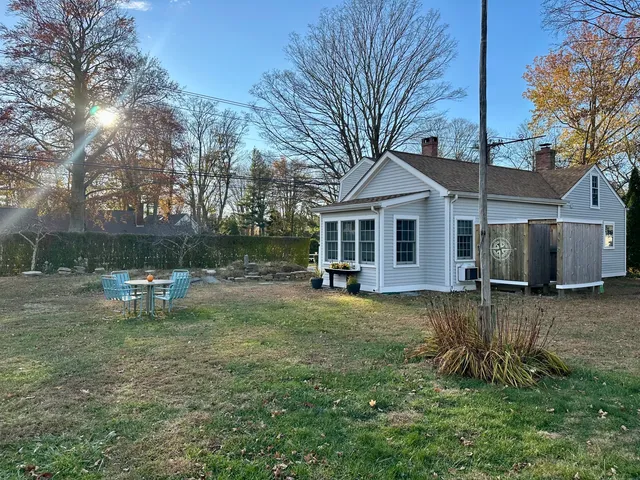 a backyard of a house with table and chairs