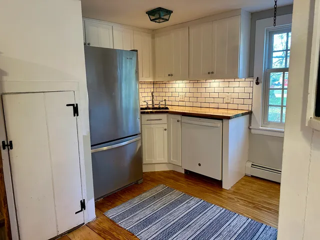 a kitchen with granite countertop a refrigerator and a sink