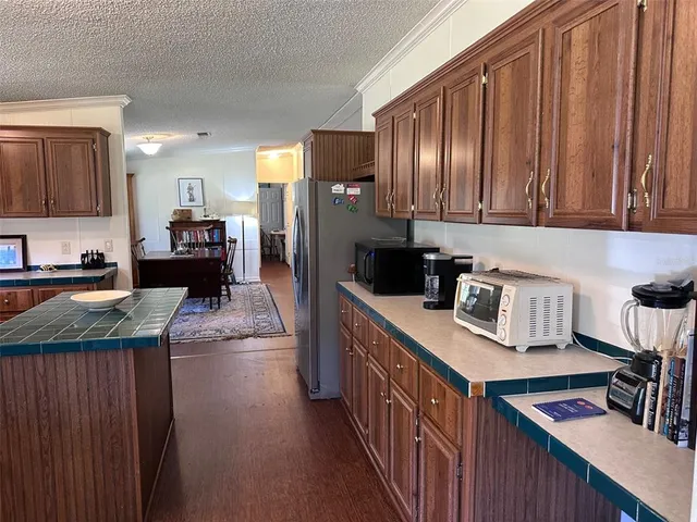 a kitchen with granite countertop a refrigerator stove and sink