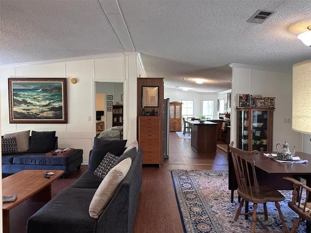 a living room with furniture and a view of kitchen