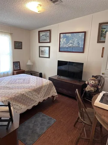 a bedroom with a bed a couch and paintings on the wall
