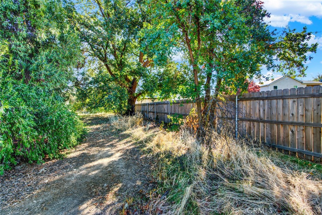 0 Toomes Corning, CA 96021 - Photo 18 of 20 a view of a backyard with large trees and wooden fence