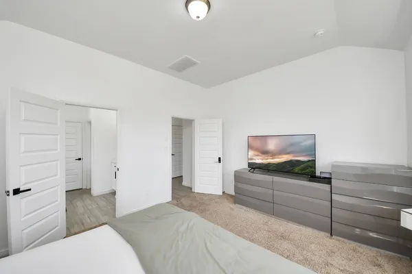 a bedroom with a bed and flat screen tv