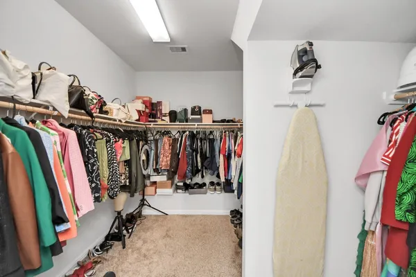 a view of walk in closet with clothes