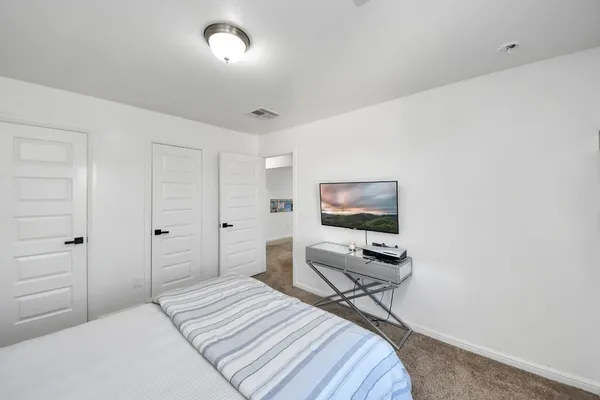 a bedroom with a bed and a flat screen tv
