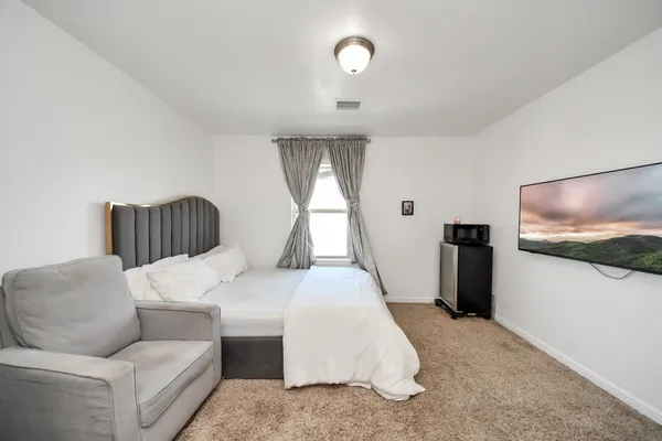 a bedroom with bed and a flat screen tv
