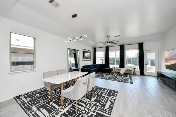 a living room with furniture two window and a table