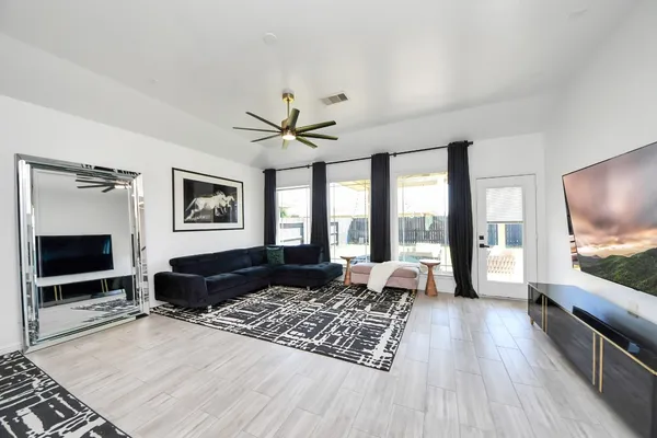 a living room with furniture a flat screen tv and a fireplace