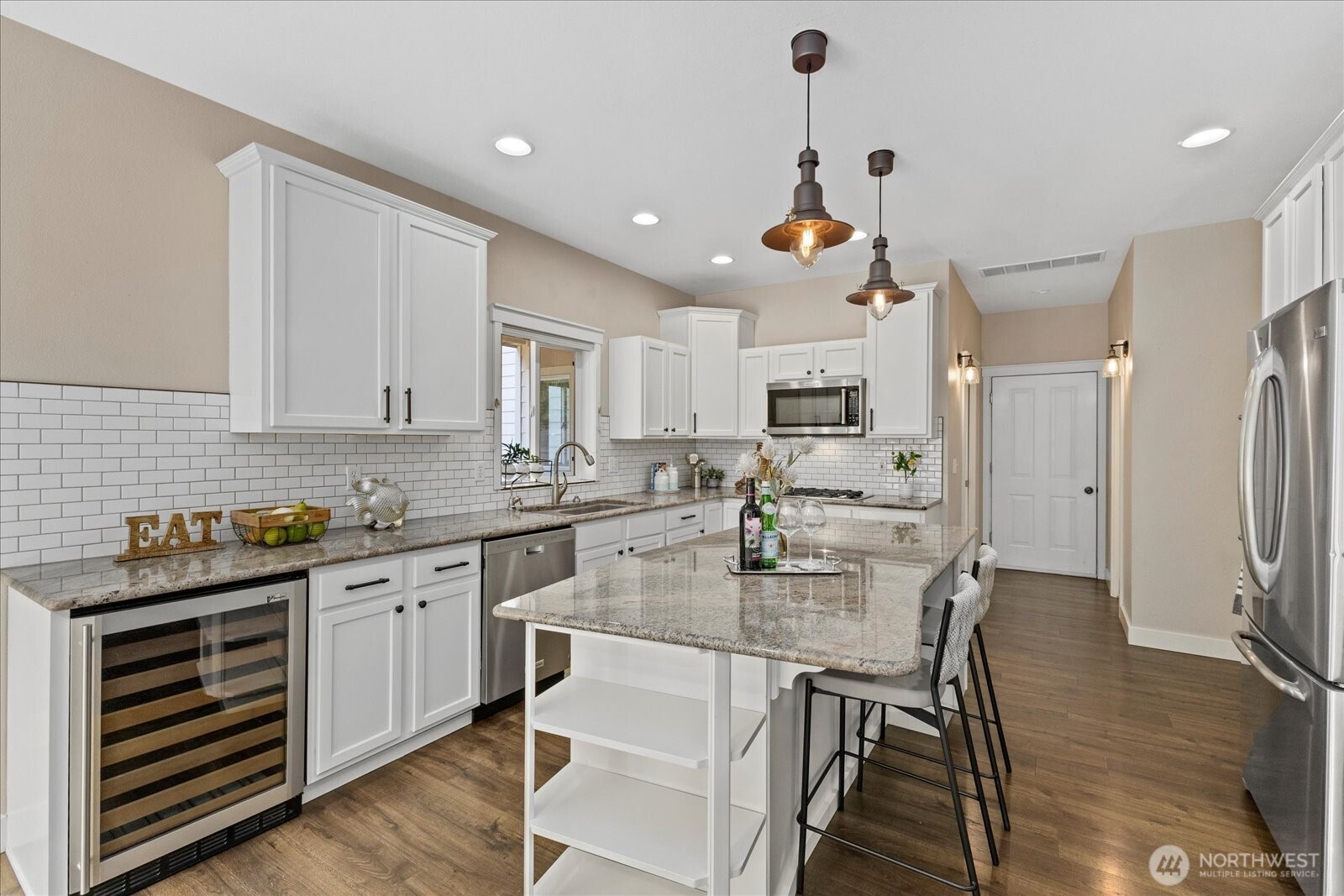 22005 260th Avenue Southeast Maple Valley, WA 98038 - Photo 16 of 39 a kitchen with stainless steel appliances granite countertop a kitchen island hardwood floor and a sink