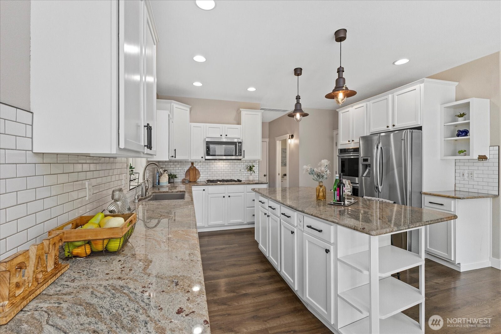 22005 260th Avenue Southeast Maple Valley, WA 98038 - Photo 17 of 39 a kitchen with stainless steel appliances kitchen island granite countertop a stove a sink and a refrigerator