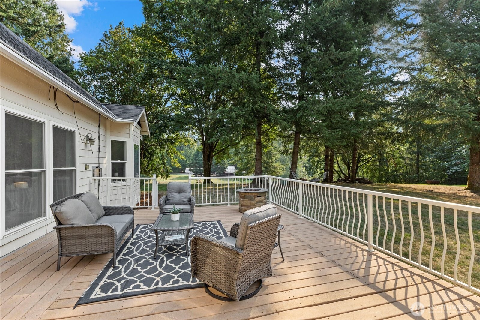 22005 260th Avenue Southeast Maple Valley, WA 98038 - Photo 26 of 39 a view of a patio with couches and a table and chairs with wooden floor and fence
