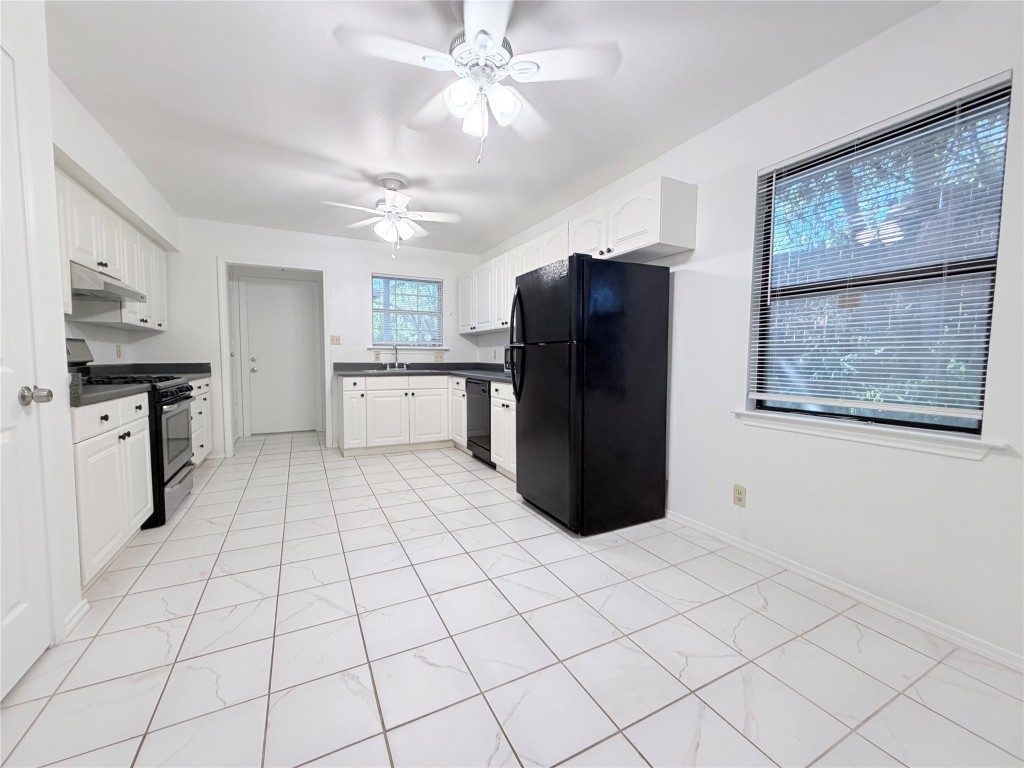 a kitchen with stainless steel appliances granite countertop a refrigerator and a stove top oven