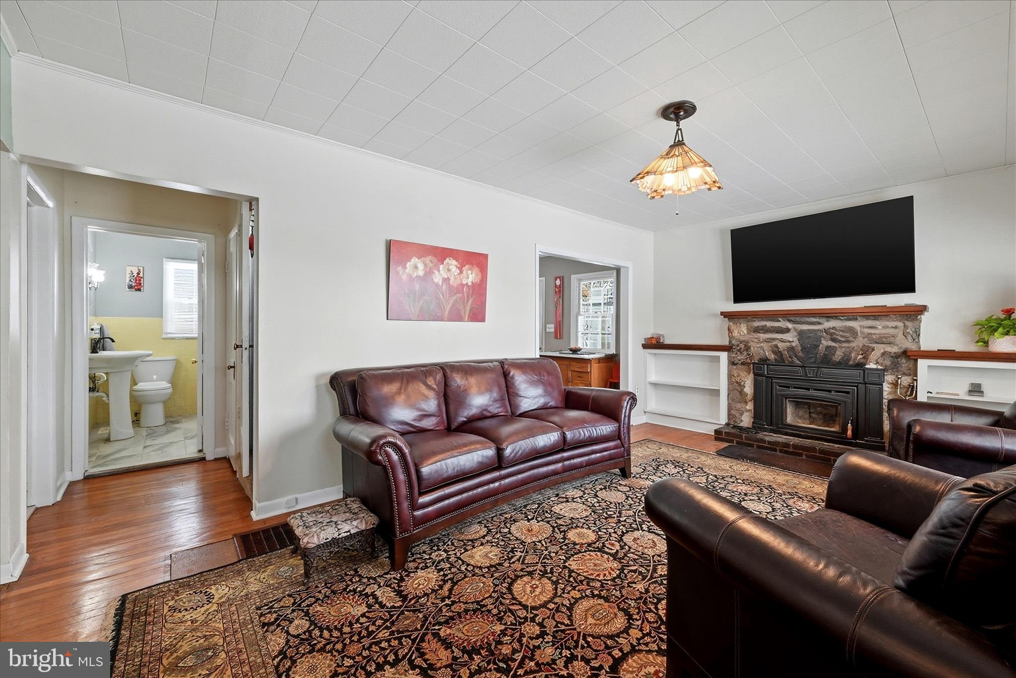 18758 Telegraph Springs Road Purcellville, VA 20132 - Photo 4 of 59 a living room with furniture a flat screen tv and a fireplace