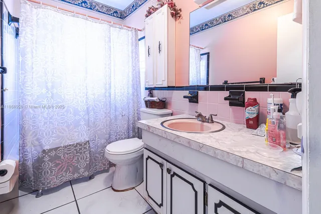 a bathroom with a granite countertop sink a toilet and a mirror