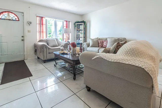 a living room with furniture and a floor to ceiling window