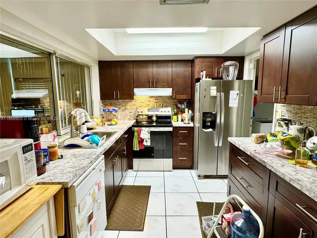 a kitchen with stainless steel appliances granite countertop a refrigerator sink and stove