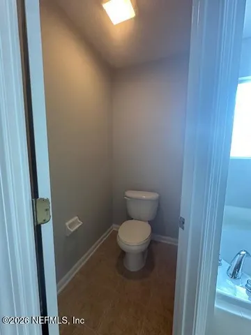 an empty room with windows and ceiling fan