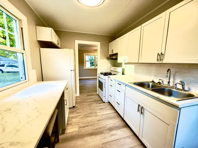 a kitchen with kitchen island a sink a stove and a refrigerator