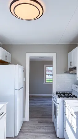 a kitchen with stainless steel appliances granite countertop a refrigerator a stove a sink and a wooden floors