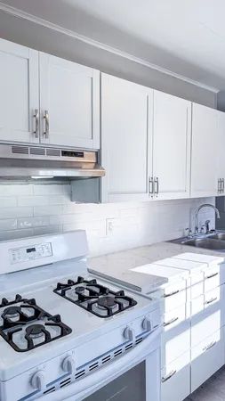 a white stove top oven sitting inside of a kitchen