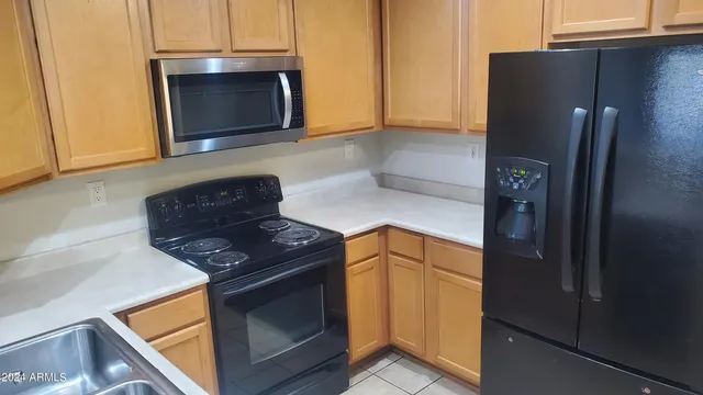 a kitchen with stainless steel appliances granite countertop a refrigerator and a stove top oven