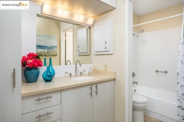 a bathroom with a granite countertop sink a toilet and shower