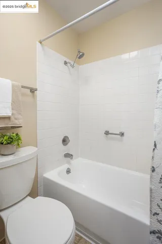 a white toilet sitting next to a bath tub