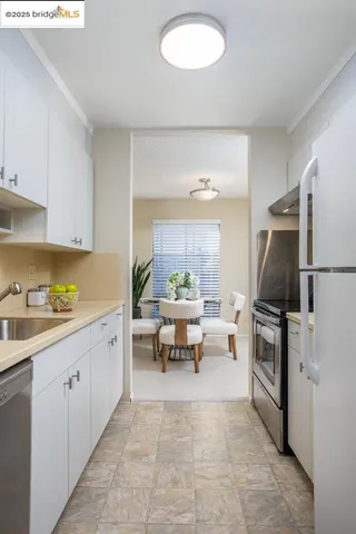 a kitchen with a refrigerator and a stove top oven
