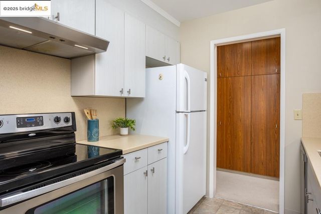 a kitchen with a refrigerator and a stove top oven