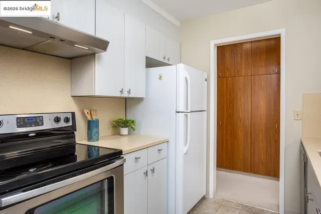 a kitchen with a refrigerator and a stove top oven