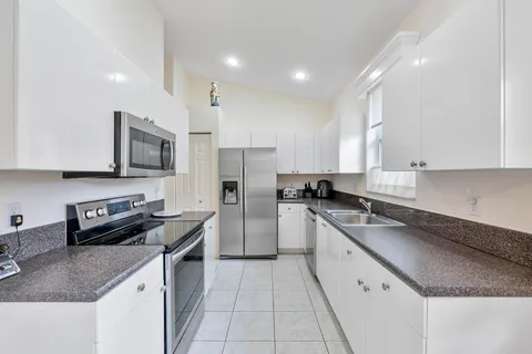 a kitchen with stainless steel appliances granite countertop a sink stove microwave and refrigerator