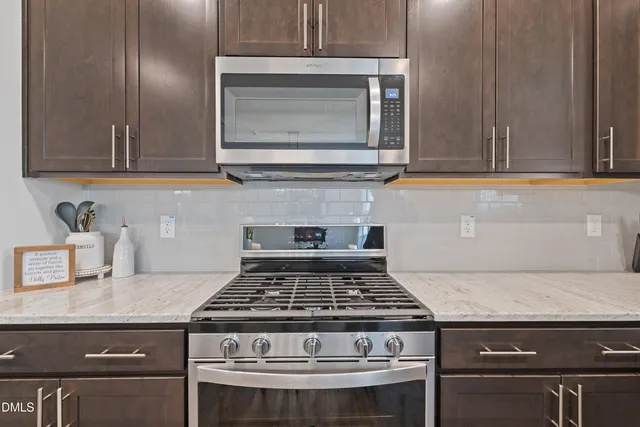 a kitchen with stainless steel appliances granite countertop a sink and a stove