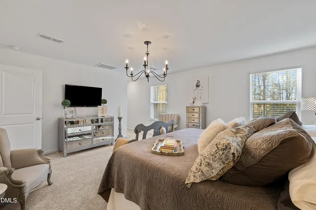 a living room with furniture a fireplace and a chandelier