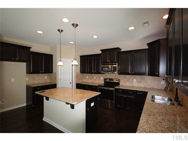 2728 Shepherd Valley Street Raleigh, NC 27610 - Photo 3 of 15 a kitchen with granite countertop a sink a counter top space stainless steel appliances and cabinets