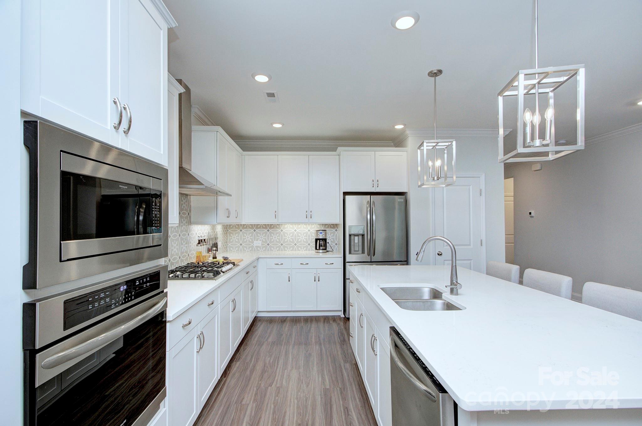 7047 Messina Road Fort Mill, SC 29707 - Photo 11 of 32 a kitchen with stainless steel appliances a sink a stove a refrigerator cabinets and a kitchen island