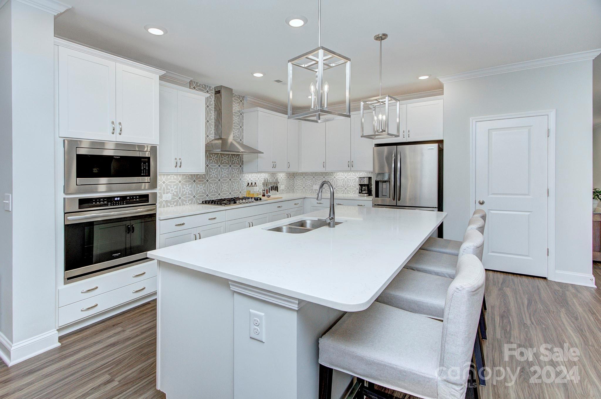 7047 Messina Road Fort Mill, SC 29707 - Photo 9 of 32 a kitchen with kitchen island a stove a sink and a refrigerator