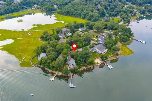an aerial view of a house with a yard and lake view