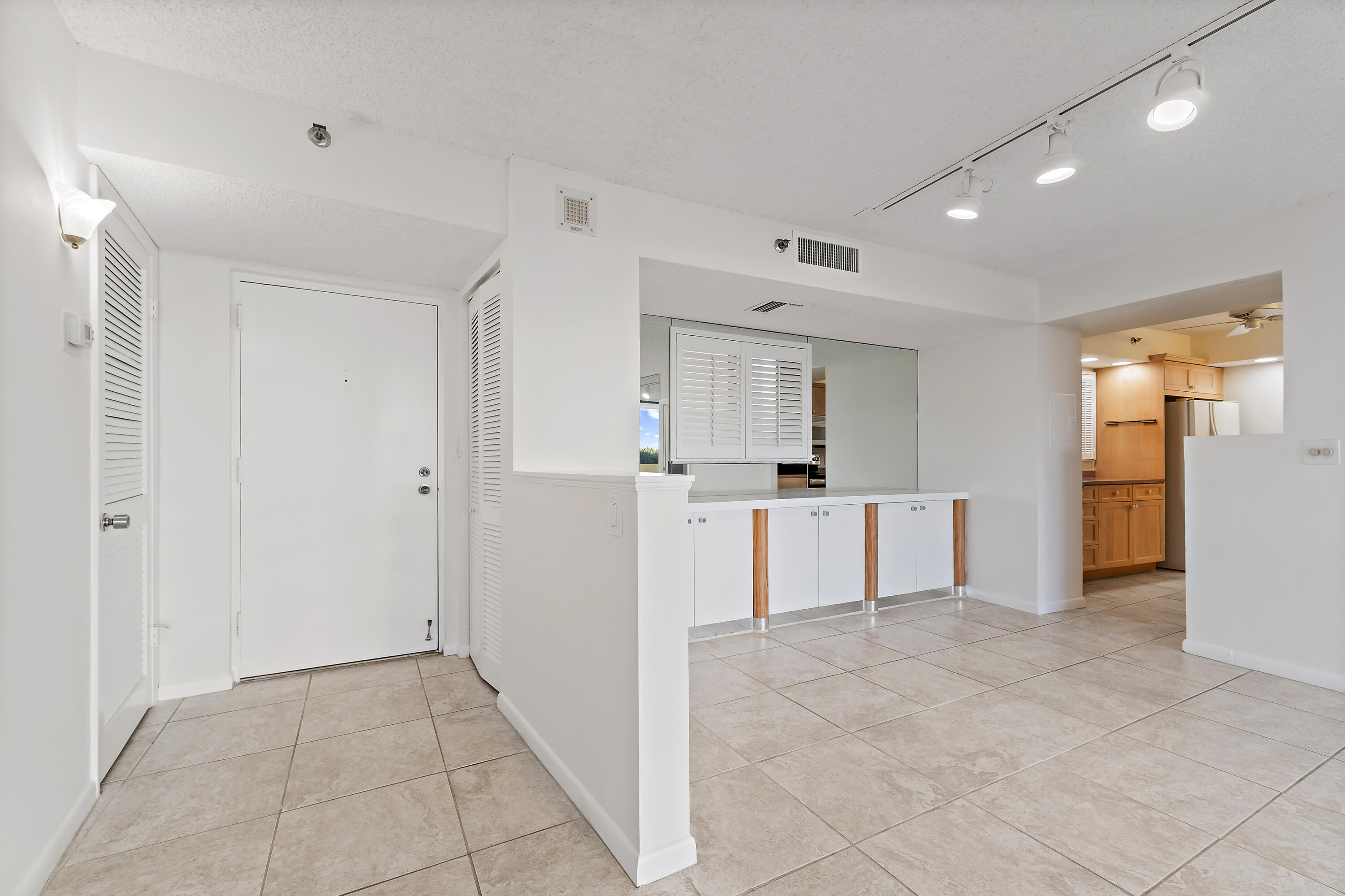 300 Ocean Trail Way, Unit 102 Jupiter, FL 33477 - Photo 7 of 30 a view of kitchen with refrigerator cabinets and wooden floor