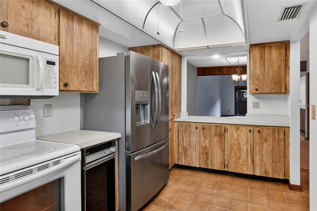 2025 Sylvester Road, Unit E1 Lakeland, FL 33803 - Photo 15 of 37 a kitchen with stainless steel appliances granite countertop a refrigerator a sink and wooden cabinets