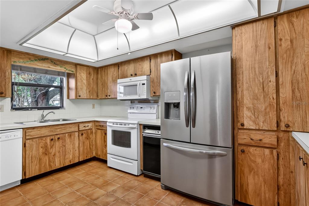 2025 Sylvester Road, Unit E1 Lakeland, FL 33803 - Photo 16 of 37 a kitchen with stainless steel appliances granite countertop a refrigerator a sink a stove and white cabinets