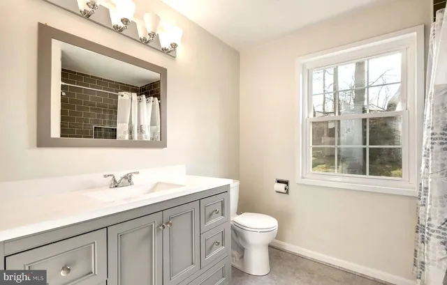 a bathroom with a sink a toilet and a window