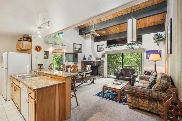 a living room with furniture and a open kitchen view