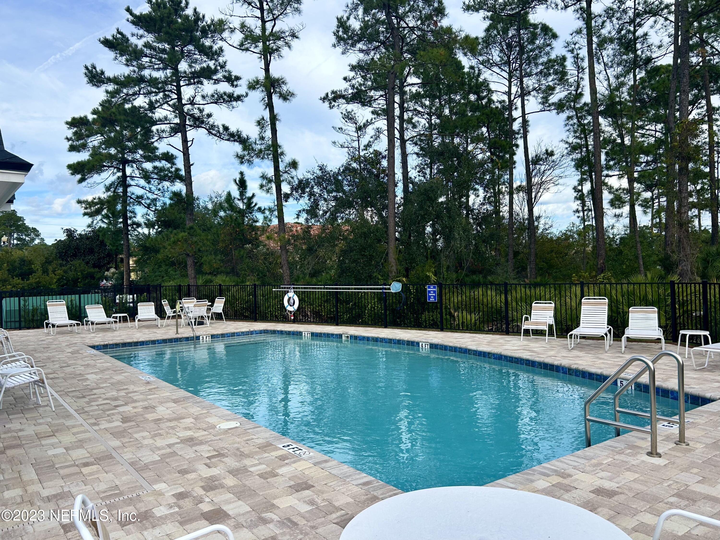 25 Ridge Lake Road St. Augustine, FL 32086 - Photo 23 of 27 a view of a swimming pool with lounge chair and trees